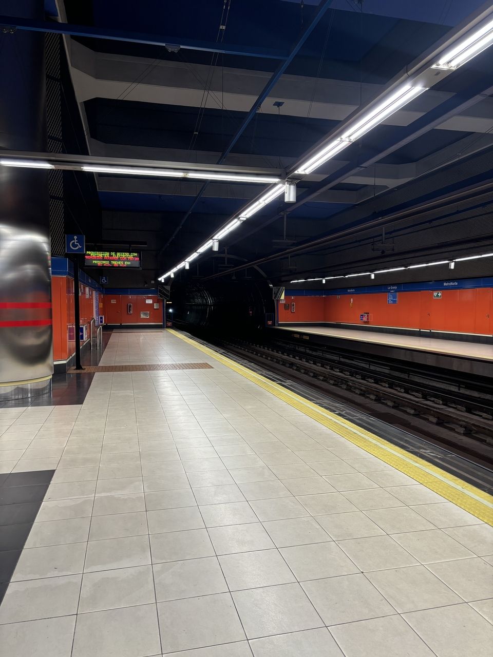 Metro platform with the headlights on the next train peeking around the corner.