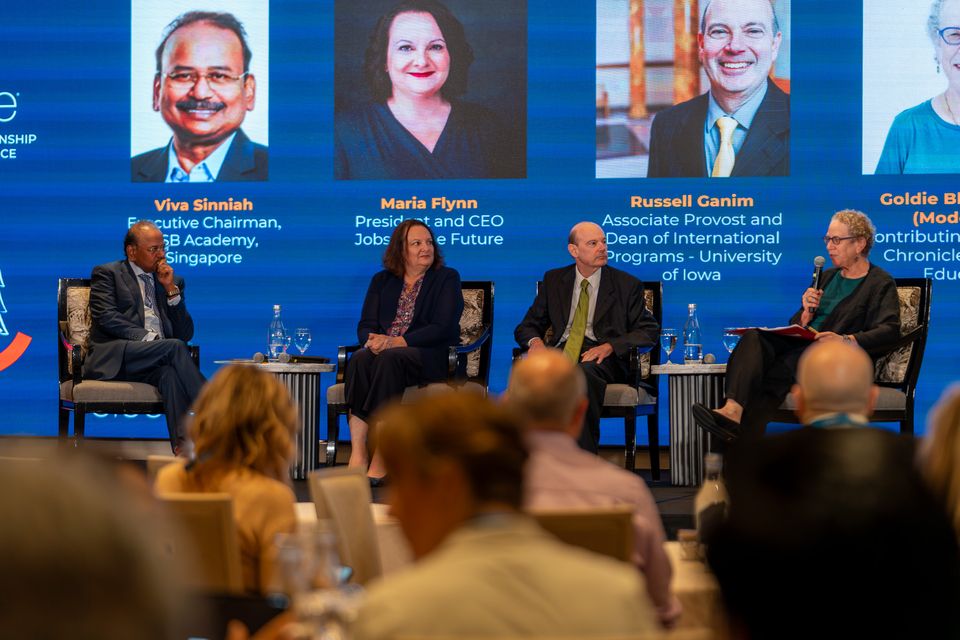 a group of 4 people sitting on a stage for a panel discussion