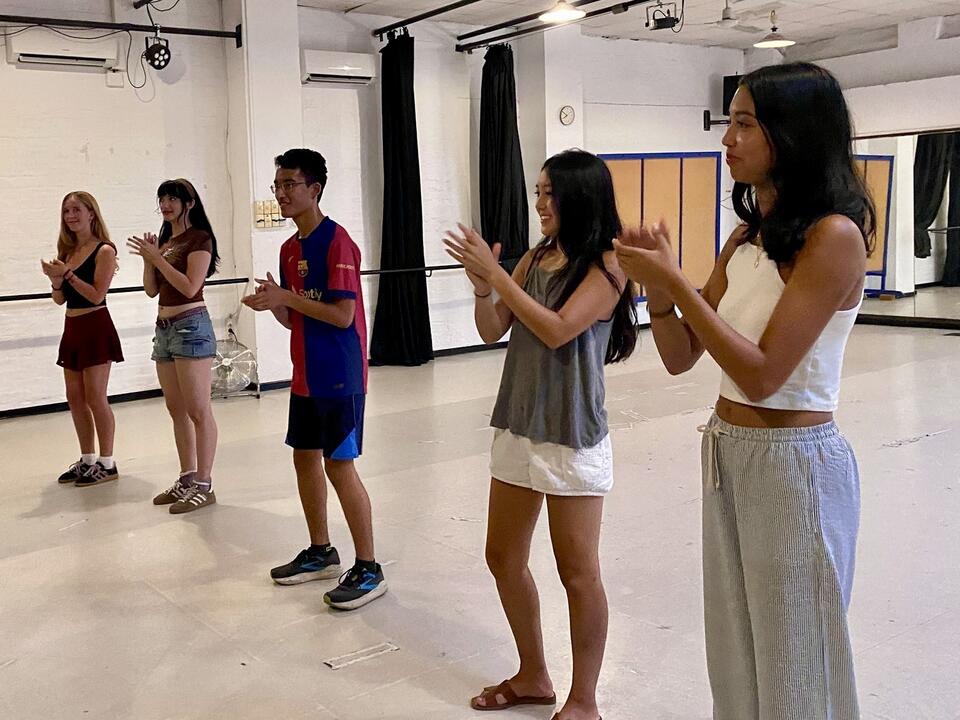 Students clapping in a small group while performing for their peers