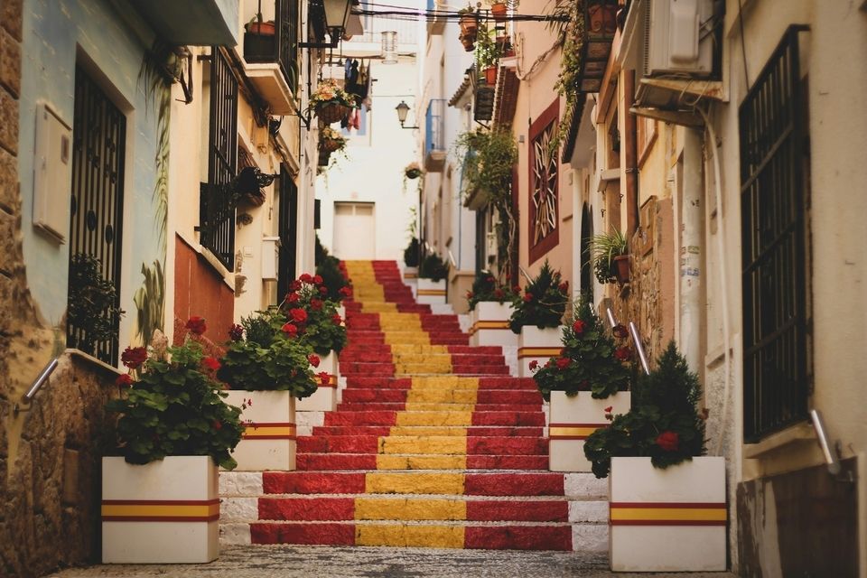 Photo of stair case painted in the colors of the Spanish flag in Old Town Calp, Spain.