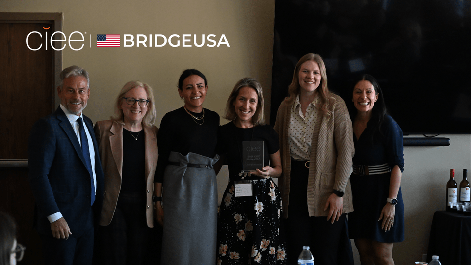 Jackie Adragna, Vice President of Human Resources at the Stein Collection, holds a 2026 CIEE BridgeUSA Champion Award with CIEE representatives during an event in Park City, Utah.