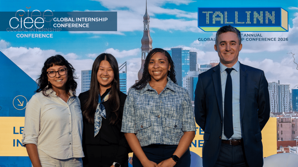 Three CIEE paid global internship participants pose with moderator Patrick Moran on stage at the 14th Annual Global Internship Conference in Tallinn, Estonia.