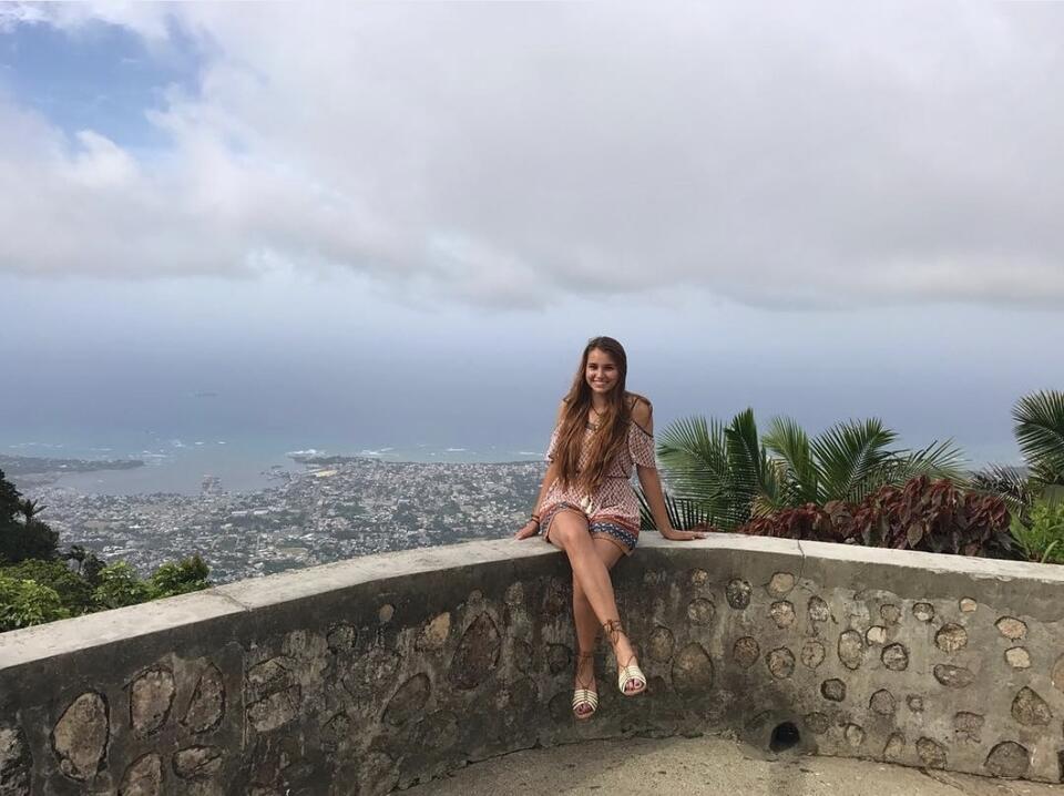 Octavia sitting on a stone overlook above Santiago de los Caballeros, Dominican Republic, during her CIEE study abroad experience in 2017.