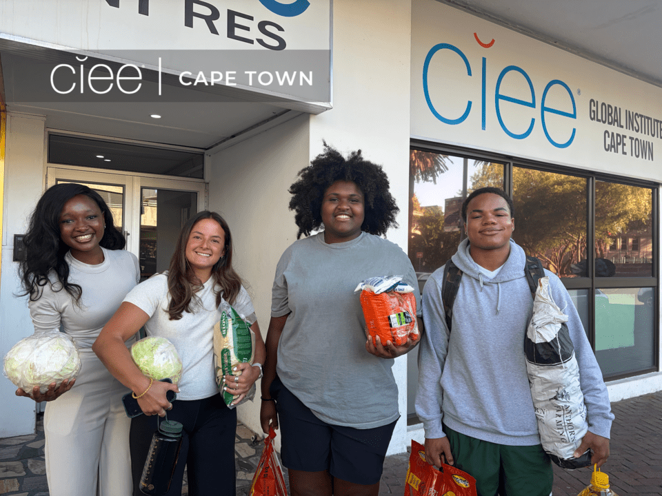 Four CIEE College Study Abroad students pose with donated food outside the CIEE Global Institute in Cape Town