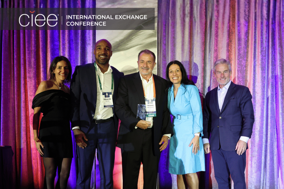Award winners pose on stage accepting their awards