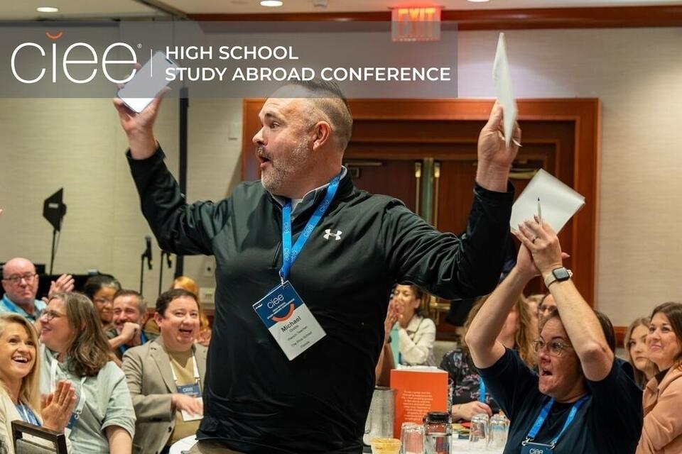 Teacher celebrates as he receives a $5,000 scholarship for one of his students.