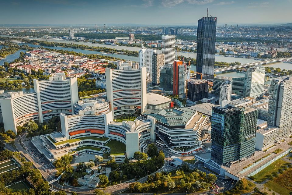 Aerial view of Donau City and UNO City (Vienna International Centre) in Vienna, Austria, featuring a dense cluster of modern skyscrapers and contemporary architecture set along the Danube River
