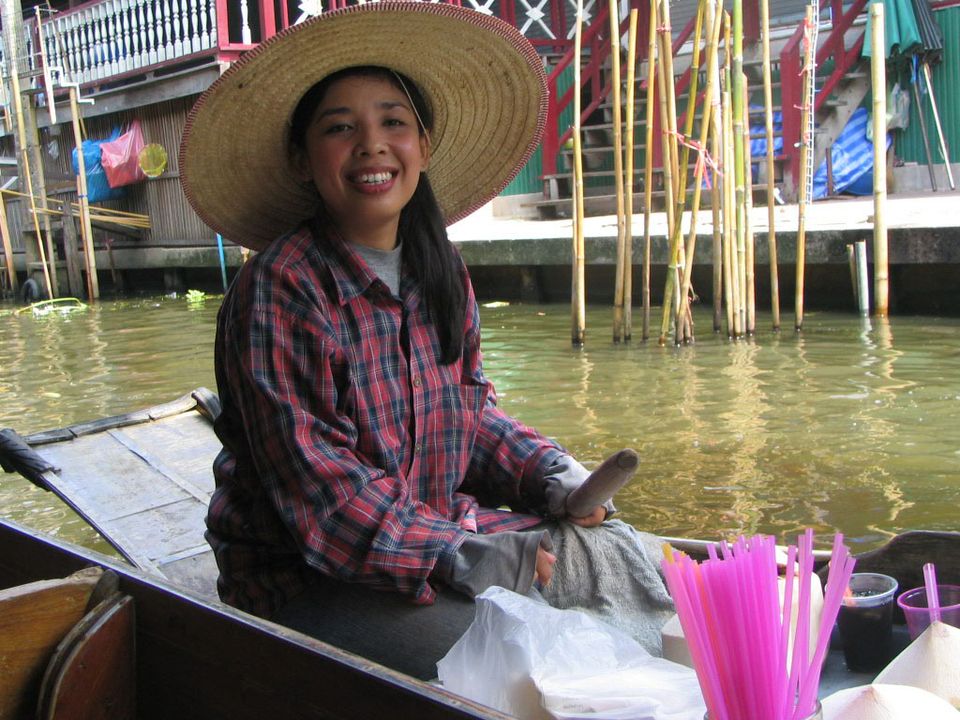 Local woman in a boat at floating market in Thailand