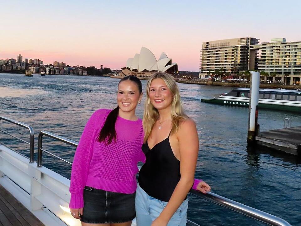 sydney-two-female-students-posing-boat-sydney-harbor-opera-house-background
