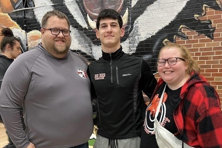 Jarred and Shannon Johnston pose with exchange student Giorgi after a wrestling match.