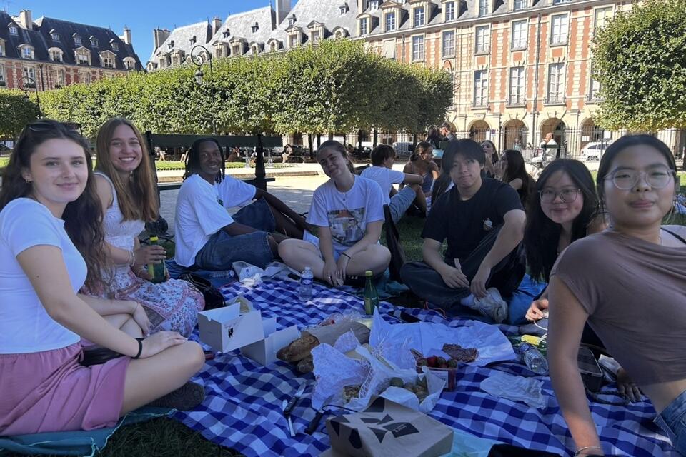 A group of Fall Study Abroad students having a picnic at Place des Vodges