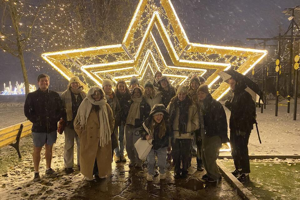 Study abroad students in Prague pose in front of Christmas lights