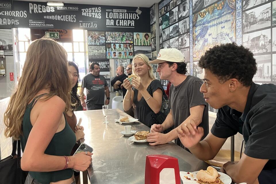 CIEE Lisbon students enjoying traditional pork sandwich bifana during a day trip to Setubal
