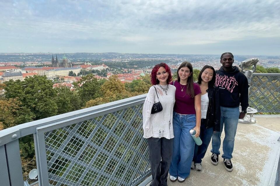 Semester in Prague program students pictured standing on Petřín Tower with a view of Prague and Prague Castle in the background